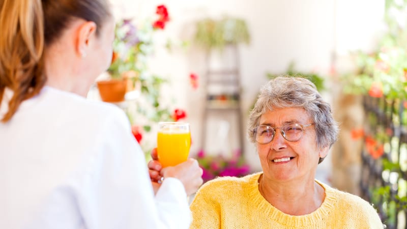 Senior drinking a mimosa during home care