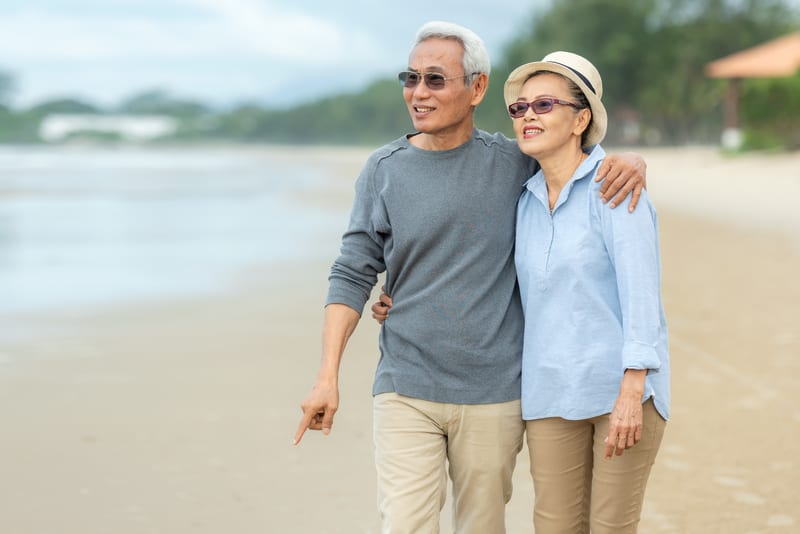Couple Strolling On Beach Photo By Wanida Prapan Dreamstime. For article, It's possible to stay safe while still enjoying Covid travel. Seniors Guide recommends tips and resources for our vulnerable population.