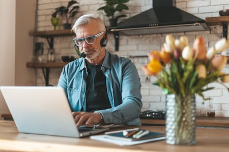 Older man working at home, having found compelling reasons to avoid retirement.