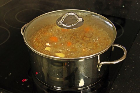 A boiling pot of beef and barley soup.