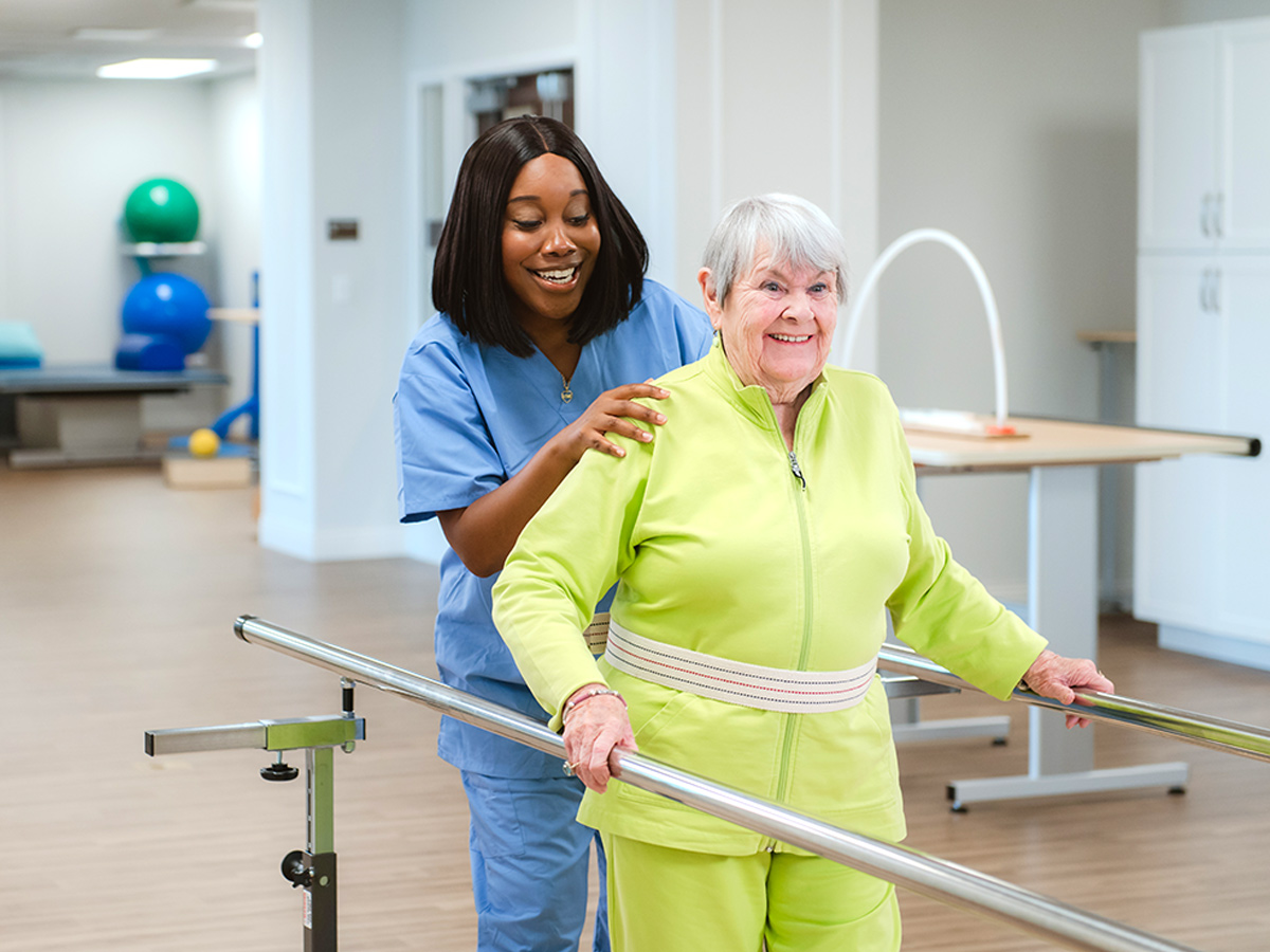 Woodlands Nursing and Rehabilitation Center Senior Lady with Caregiver Rehab Walking