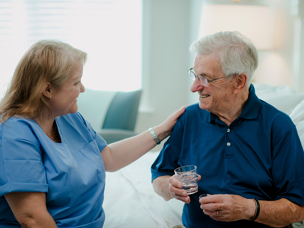 Woodlands Nursing and Rehabilitation Center Senior Man with Caregiver Drinking Water
