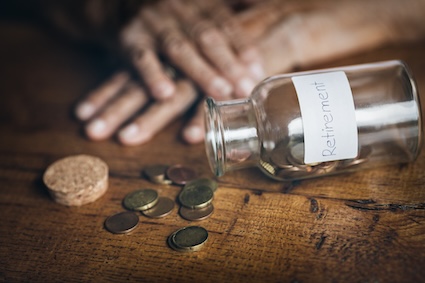 Coins falling out of a jar marked "retirement"