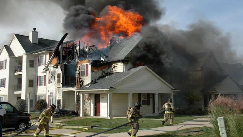 Firefighters battle a blaze, noting the issue of fire safety at senior living communities. Image by Ewegryn