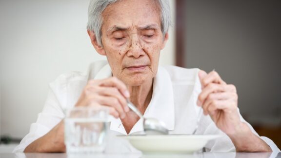 Thin elderly woman not eating, demonstrating issue of eating disorders among seniors. Image by Satjawat Boontanataweepol
