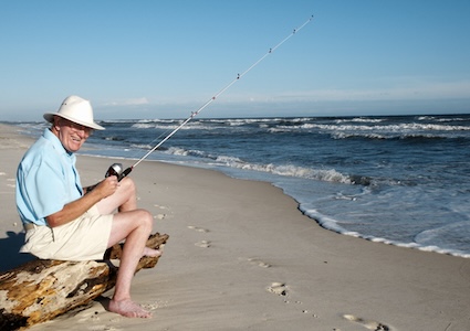 Man fishing on the beach in Perdido Key, Florida, demonstrates why people retire in Florida. Image by Dvest