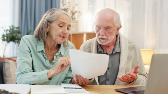 A couple frustrated on a computer trying to stay on top of costly medical bills.