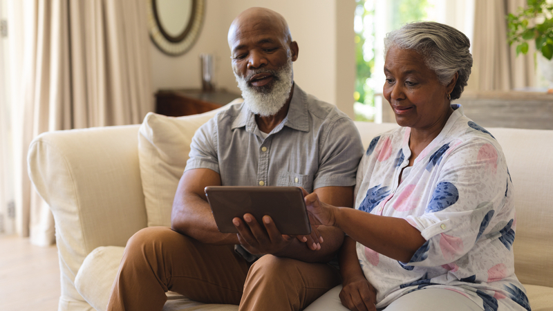 Couple with a tablet, working on crossword puzzles for seniors. Image by Wavbreakmedia Ltd