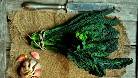 Kale and garlic on a cutting board, prepared to help a healthy eater get your leafy greens. Image by Nicoleta Raluca Tudor
