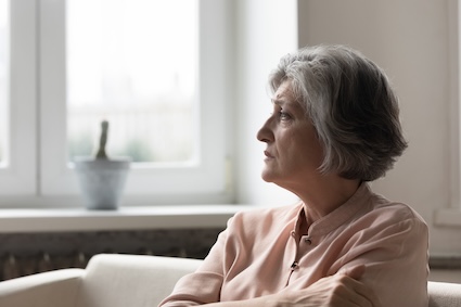 A woman is sad after her friends withdraw because of her terminal diagnosis. By Fizkes