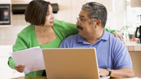 couple using computer and concerned about paper bill - maybe looking for the best Medicare plan. Image by Monkey Business Images