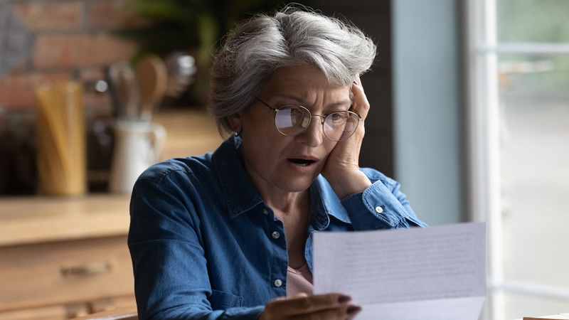A woman surprised after getting a high Medicare bill in the mail