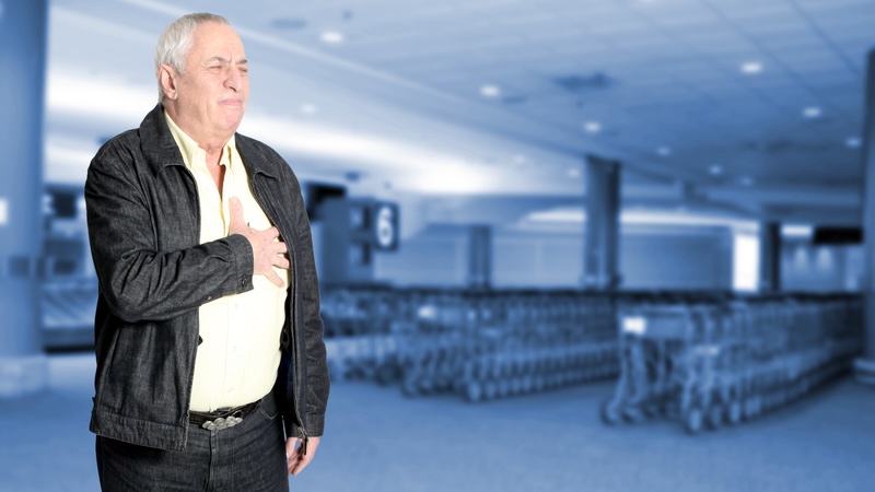 Man in grocery store clutching his chest because of an abnormal heartbeat