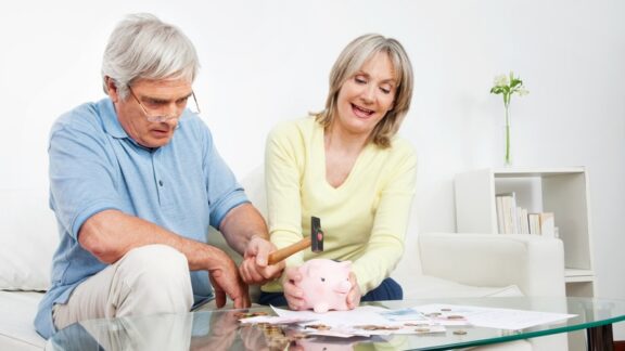 Couple breaking a piggy bank even though they want to protect their savings.