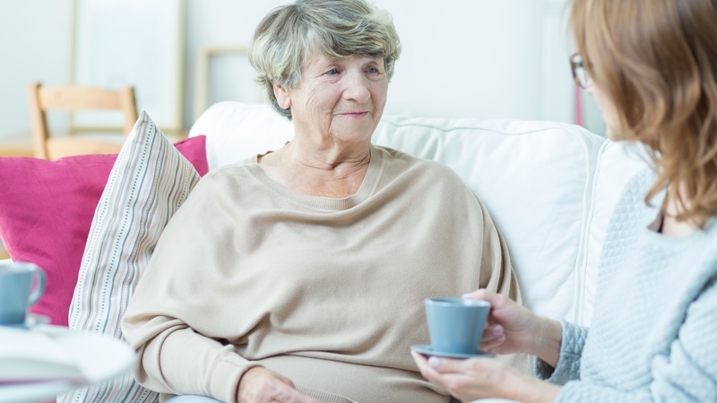 A senior with a caregiver at home, for article on caregiver criticism. Image by Bialasiewicz