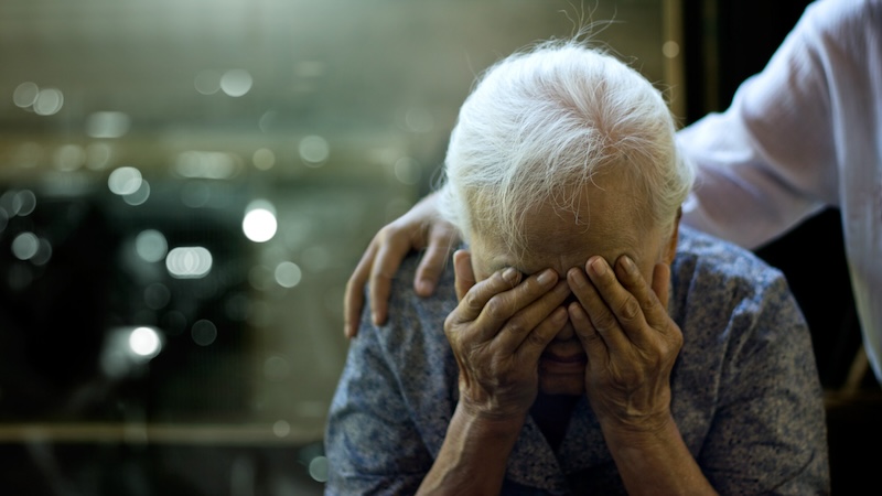 A caregiver comforts an elderly person. Knowing the 7 stages of dementia before death can help in managing the challenges. Image by Pop Nukoonrat.