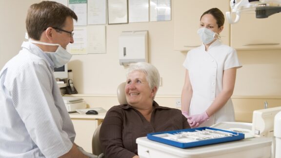 A senior at the dentist about to pay for dental costs