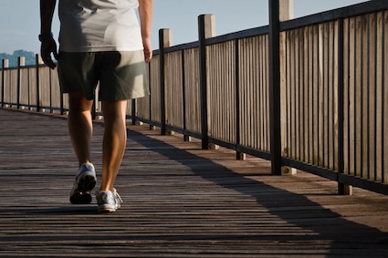 A man takes a stroll along a boardwalk. Movement such as walking is among the healthy morning habits for seniors. Image by Kschua