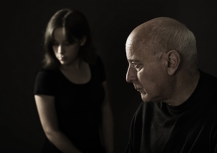 A daughter and father in black, representing their grief. Image by Larisa Lofitskaya