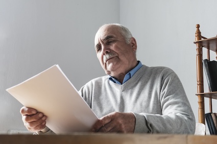 A man looking at papers, recalling a journal where he has been tracking life