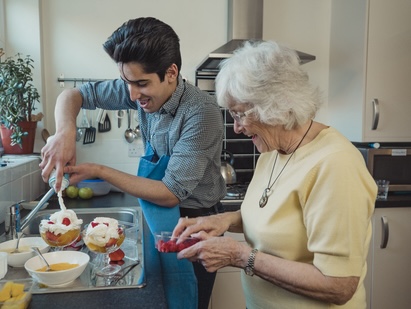 Grandmom cooking with grandson smiling.