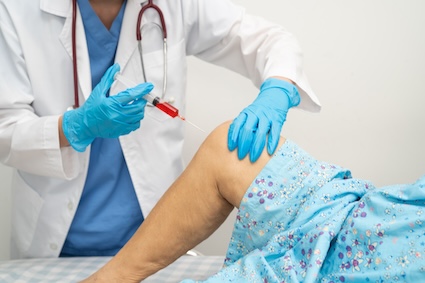 Woman getting an injection because of her osteoarthritis.