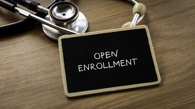 a blackboard that says open enrollment. For healthcare