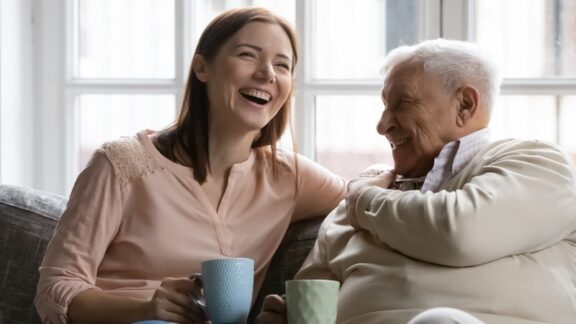 An adult daughter understands the value of visits and enjoys coming to see her elderly father. Image by Fizkes