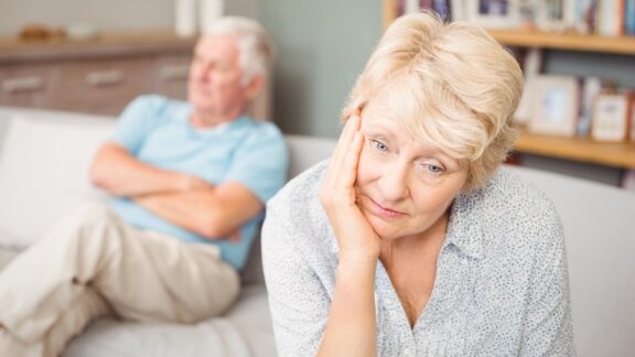 A senior couple arguing, unhappy with each other, potentially facing the emotional challenges of a staggered retirement.
