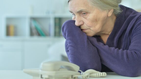 Woman waiting by a silent phone wondering if she should let the relationship die.