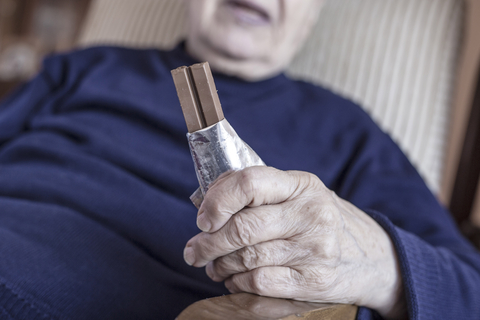 A senior eating a chocolate bar, by bbbrrn. By checking in on seniors, a concerned friend or family member can find out if they're eating poorly.