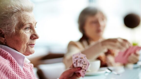 A friend's cognitive issues are apparent as women play cards.