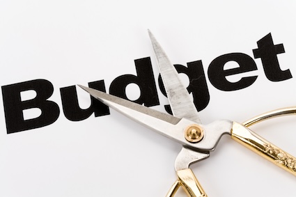 The word "budget" and scissors illustrating your desire to trim your monthly budget.