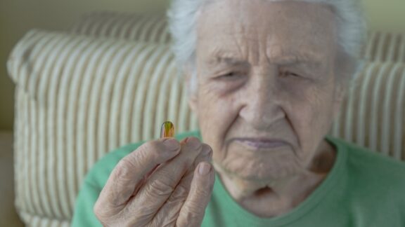 A self-medicating sister holding up a pill.