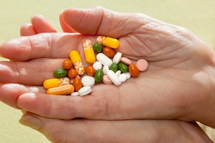 A self-medicating sister holding so many pills in her hands.