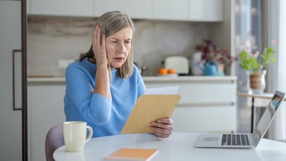 A woman looking at a document worried about her Social Security COLA
