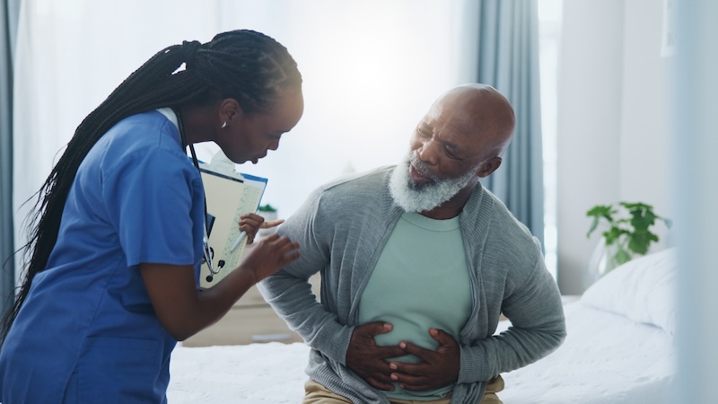Man holding his stomach explaining the signs of food poisoning