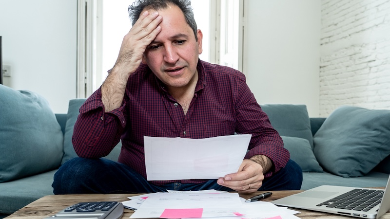 A man looking sadly at health care bill, hoping for health care tax write-offs