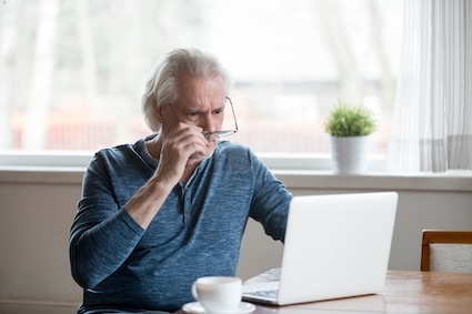 Man on computer stressed about Medicare tax torpedo