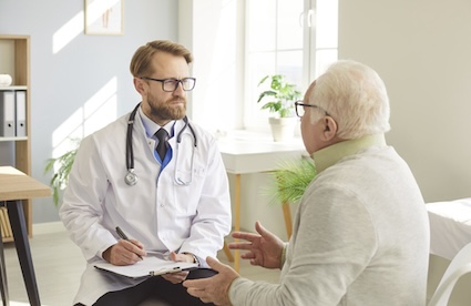 A man meeting with his doctor, getting difficult health news.
