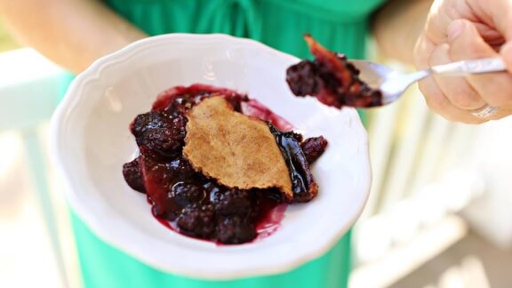 A woman holds a bowl on sonker, a part of the heritage North Carolina food scene.