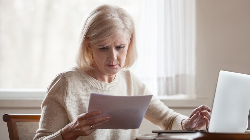 Woman worried about a written document because of soaring health care premiums