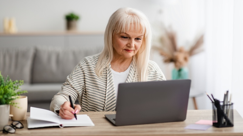 Woman on her computer making a portfolio checklist for retirement.