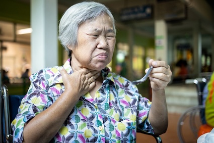 A woman eating with a sore throat.