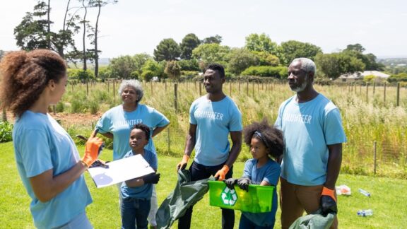A family volunteering in nature with trash pickup. By wavebreakmedia