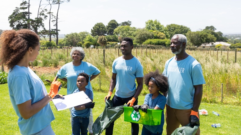 A family volunteering in nature with trash pickup. By wavebreakmedia