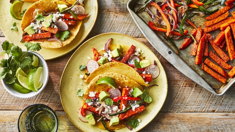 A no-meat fajita ready to eat on a plate next to delectable vegetables.