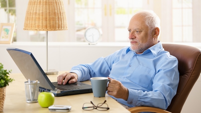 A senior navigating medicare enrollment on his laptop.