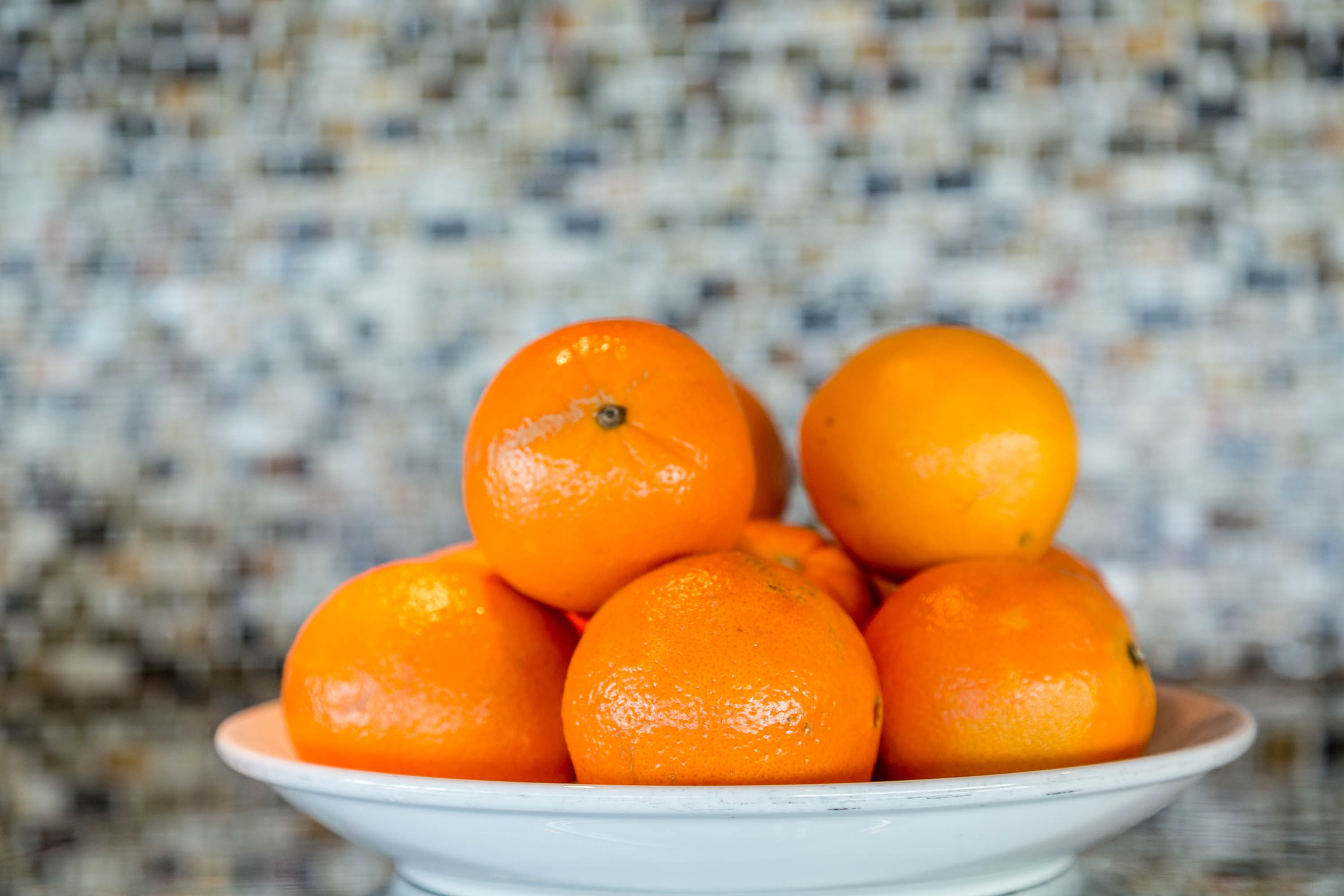 Oranges in a bowl. Someone put them there because they're familiar with the health benefits of oranges.
