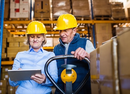 Older woman and man working in a warehouse, having delayed retirement. Pojoslaw